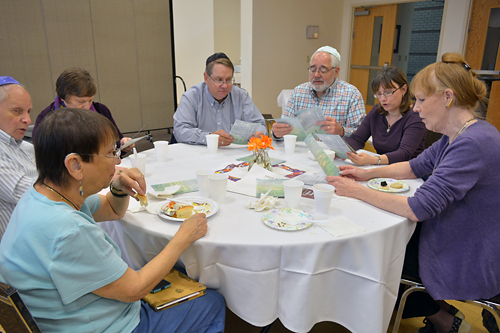 People sitting at a table singing Birkat